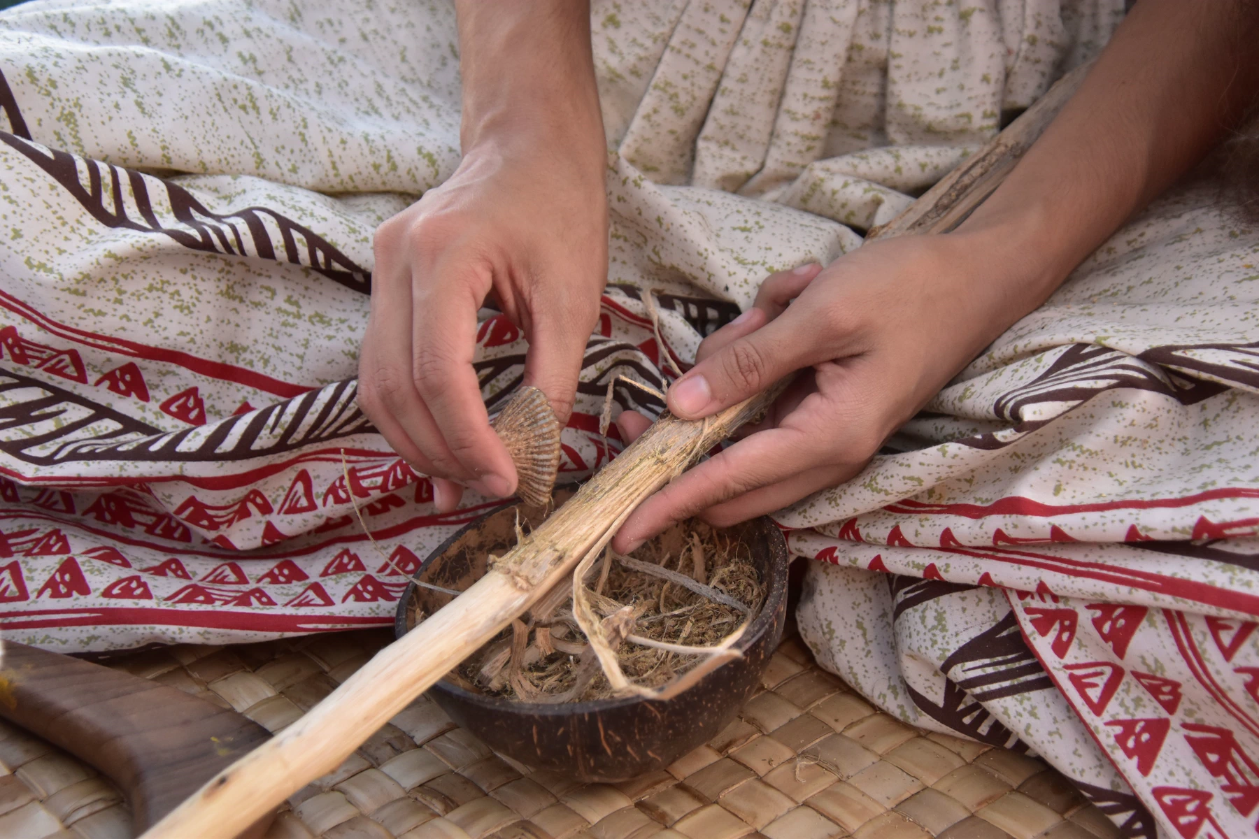 Hands shape a natural plant fibre using a traditional craft process