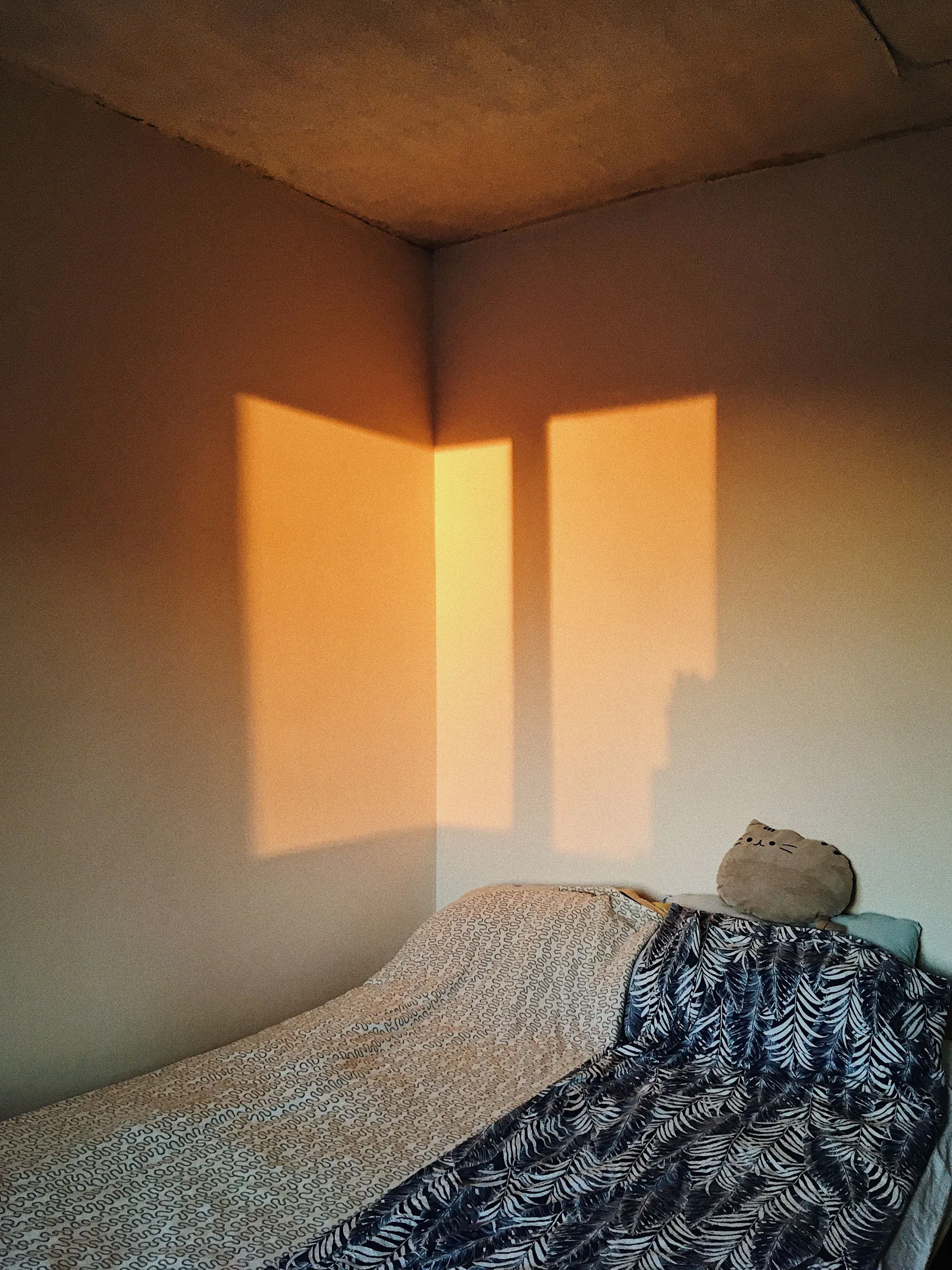 Low morning sun crosses a quiet bedroom